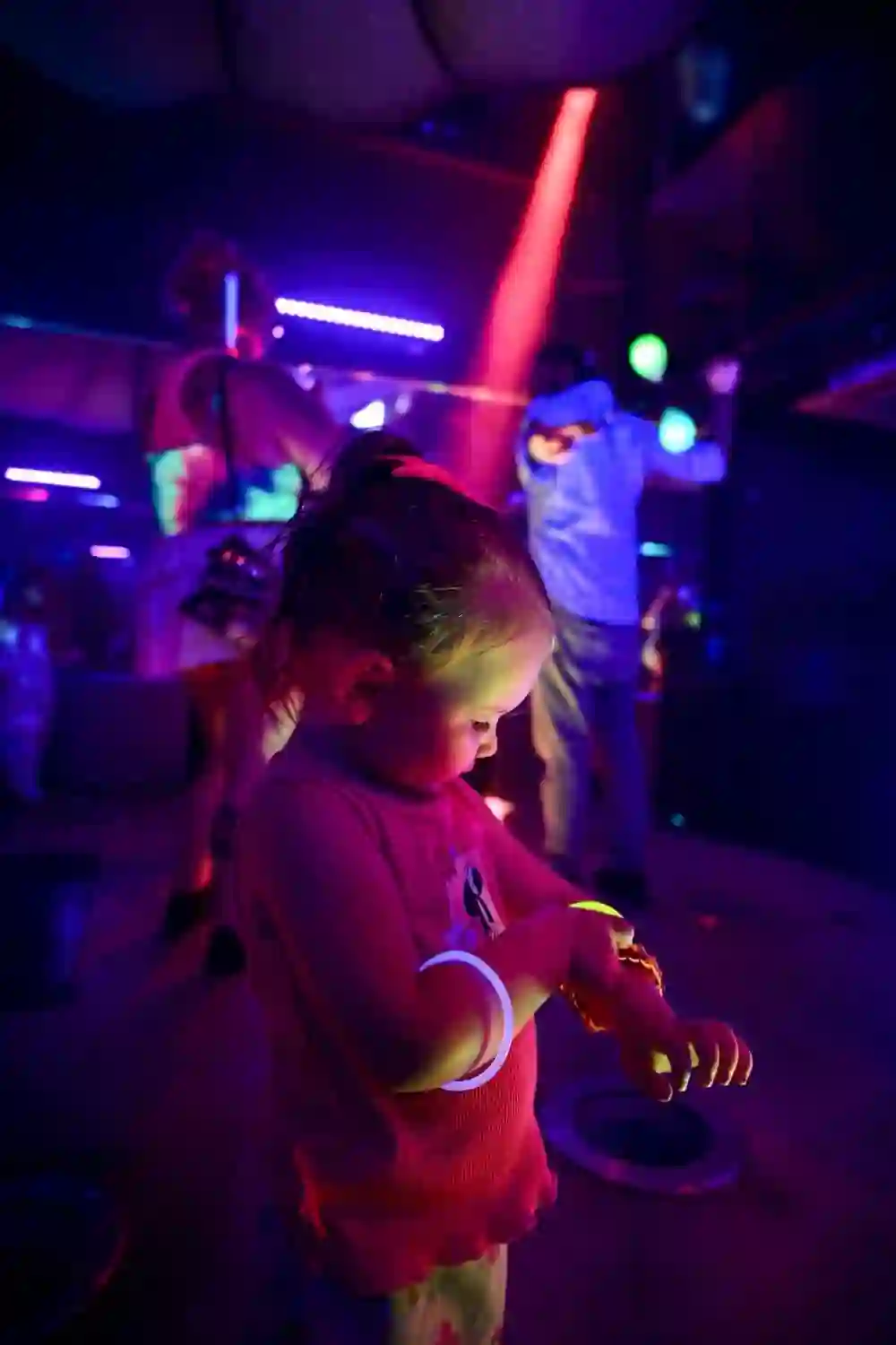 Little girl in a glow bracelet lit pink and yellow