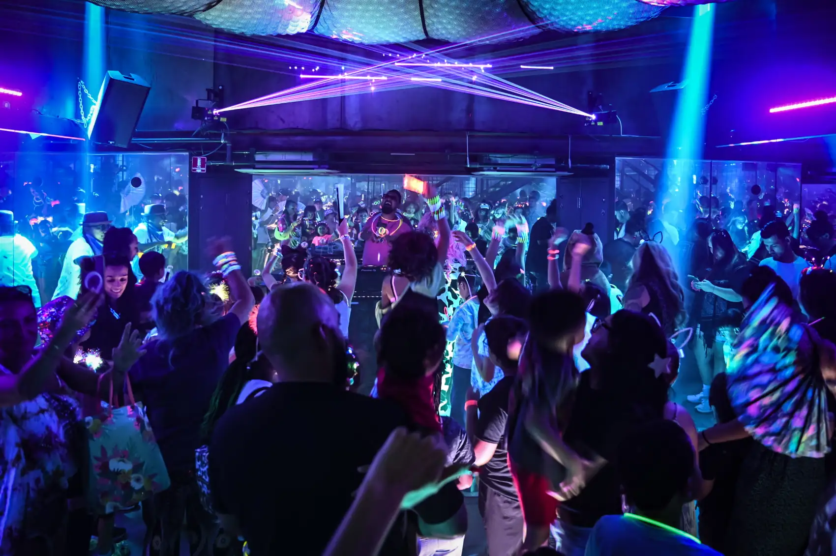 A packed Little Ravers Society party at The Drop PHX: kids and parents dancing under lasers while the DJ plays